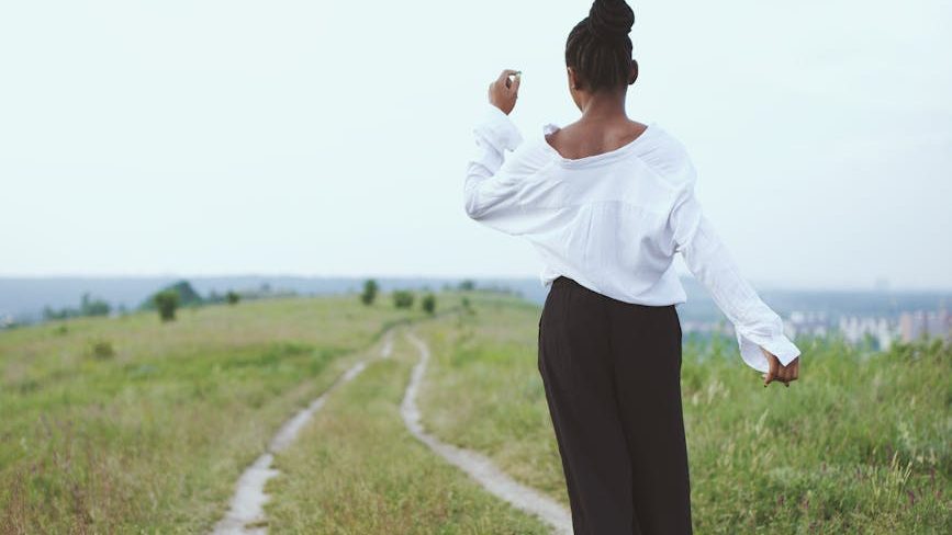 A person takes a leisurely walk in nature, promoting relaxation and connection with the outdoors. Jennifer Adair LPC, Onesta Therapy Co.