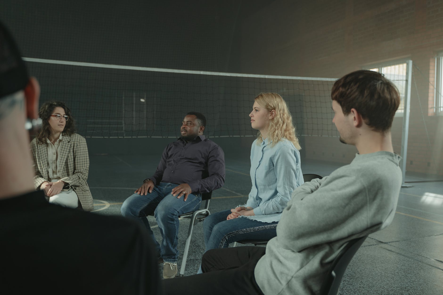 A diverse group of people holding hands in support, representing the importance of seeking community during times of grief.