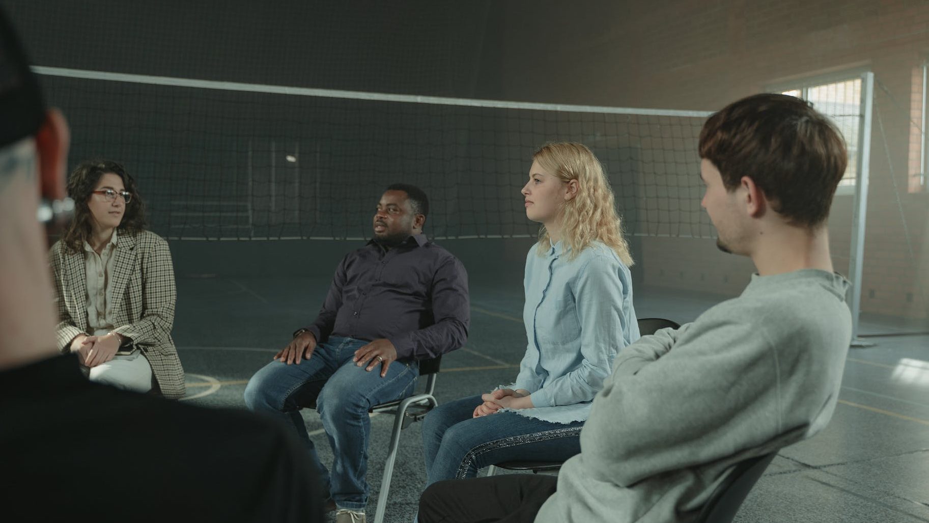 Support network in Narcissistic abuse recovery - Diverse group of people talking in a circle symbolizing support and solidarity.