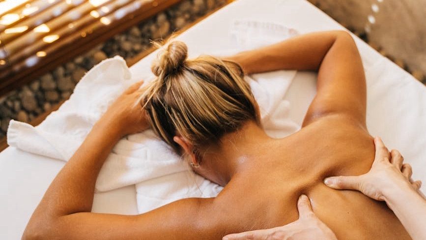 Person receiving a massage from a massage therapist in a peaceful spa setting, illustrating massage therapy as a pain management technique for chronic pain relief and relaxation.