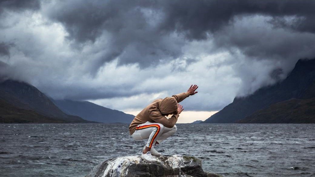 Illustration of a person surrounded by a swirling tornado of dark clouds, symbolizing negative thought patterns.