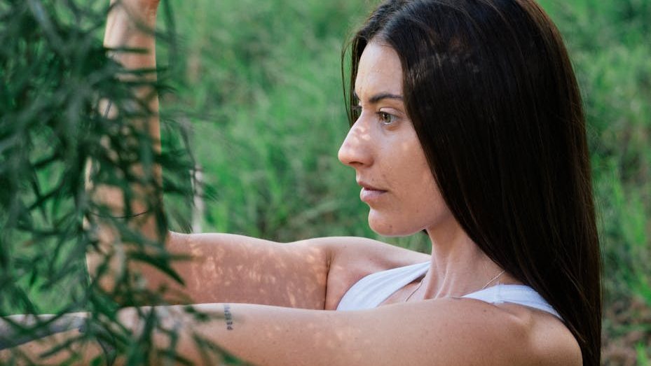 Person practicing yoga in serene outdoor setting.