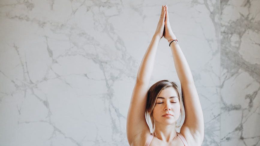 A person practices yoga in a serene environment, prioritizing self-care and mental wellness. Jennifer Adair, LPC, Onesta Therapy Co.