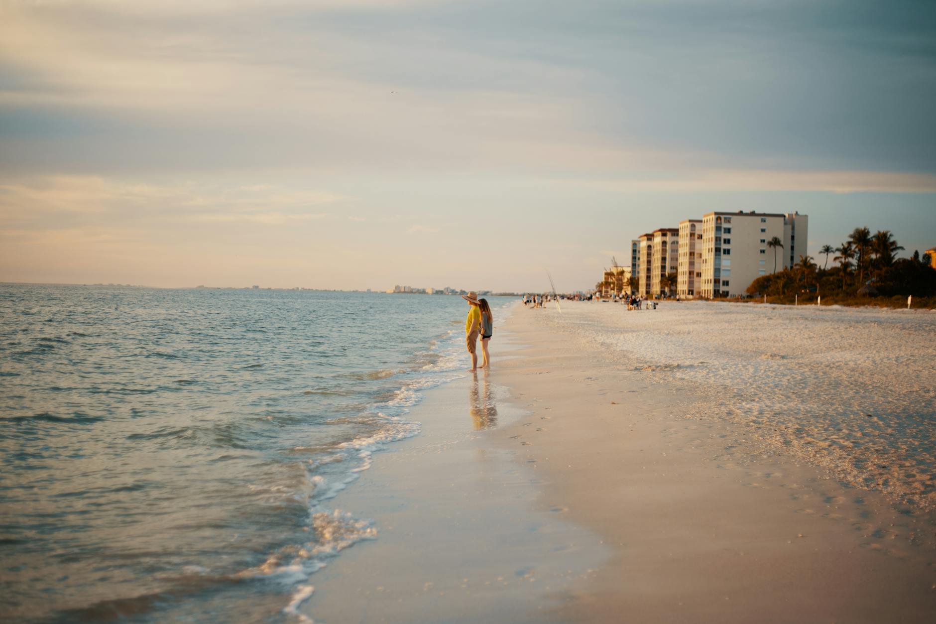 A romantic couple strolling hand in hand along the shoreline of a tranquil beach, symbolizing the importance of connection and resilience in relationships.
