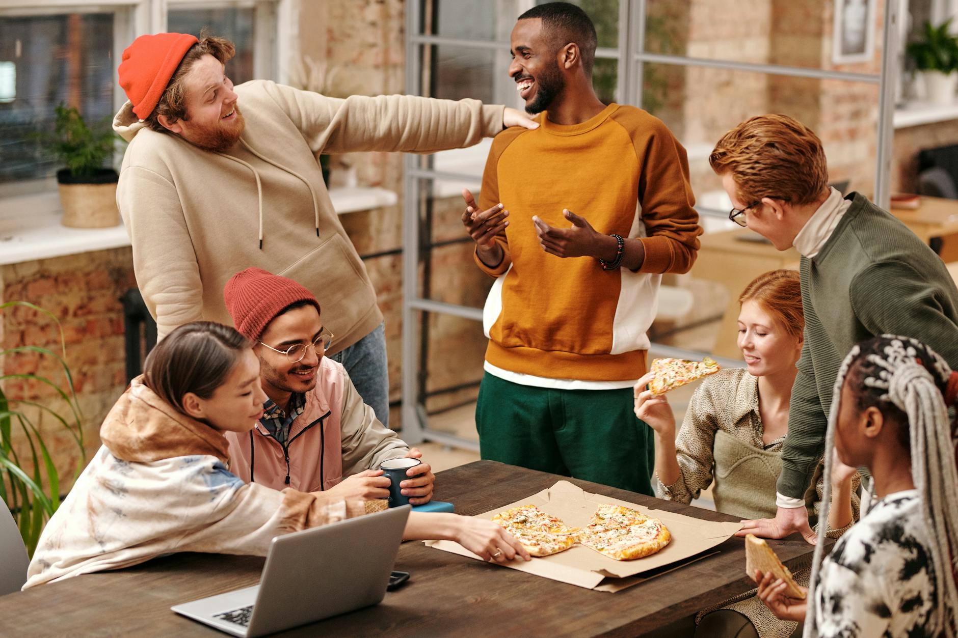 A group of friends smiling and laughing around a table, sharing a meal and fostering social connection and support, even in the face of chronic pain.
