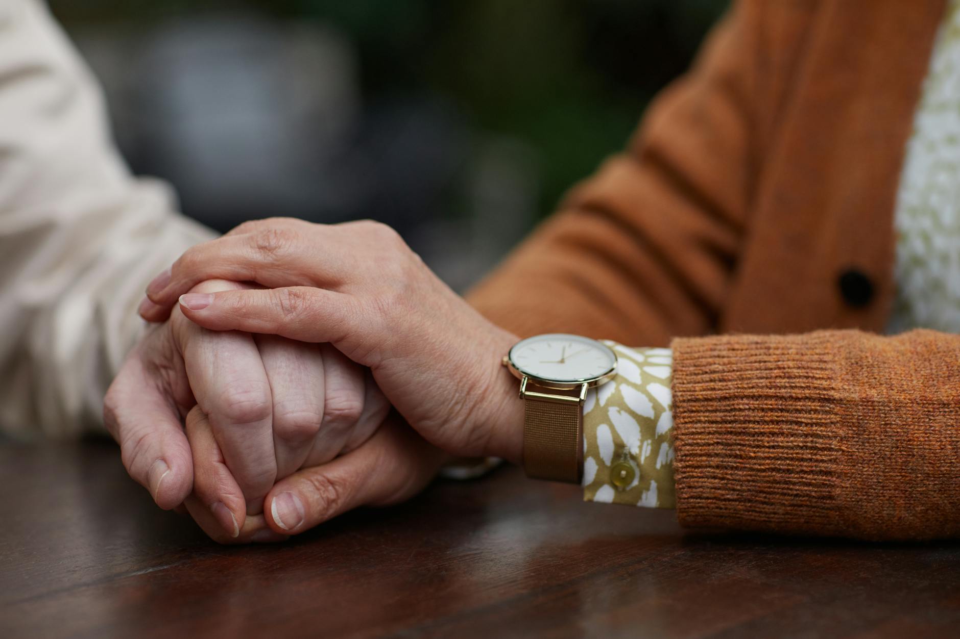 A close-up of two hands clasped together, representing vulnerability, trust, and support in relationships.