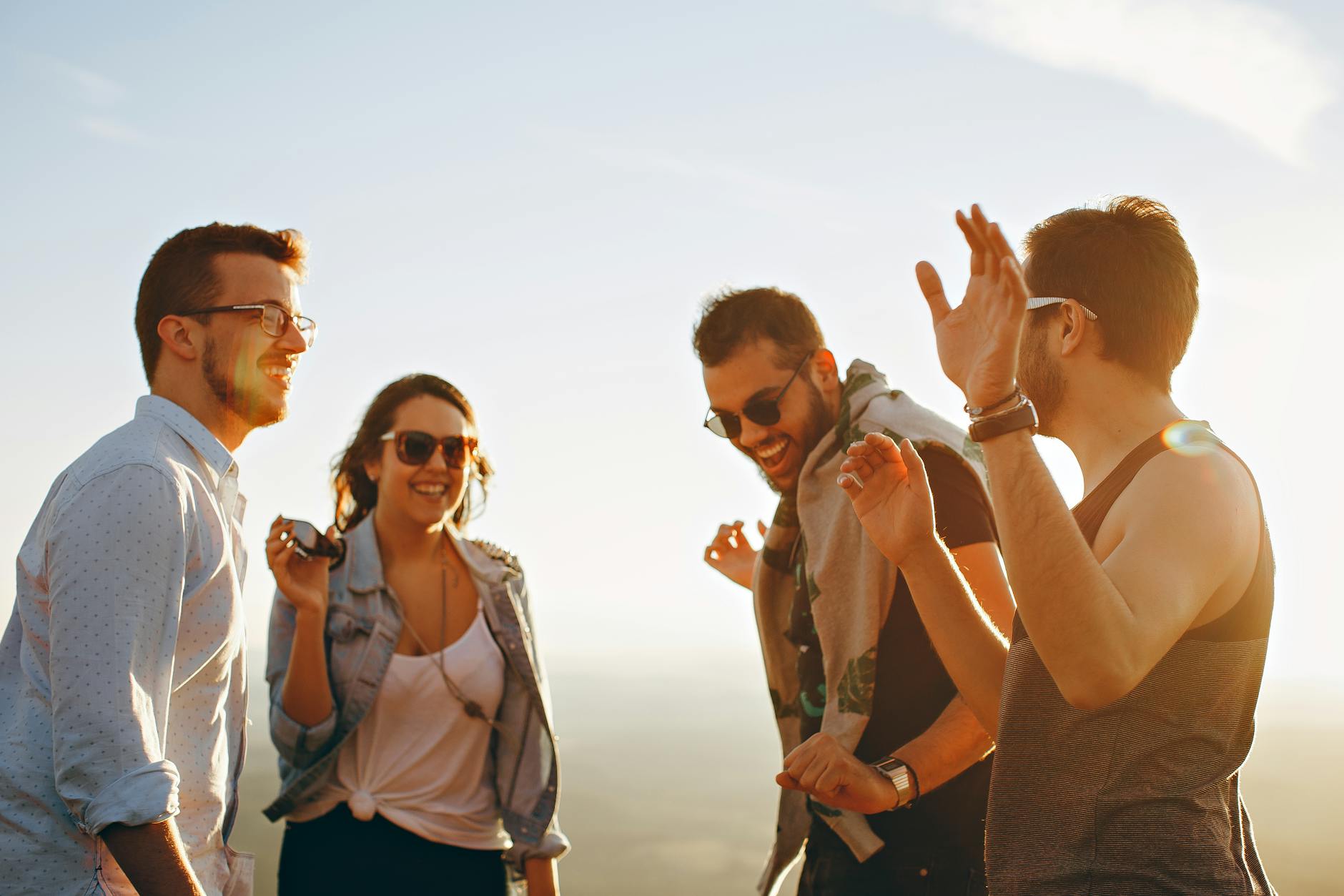 Group of friends laughing and enjoying each other's company outdoors.