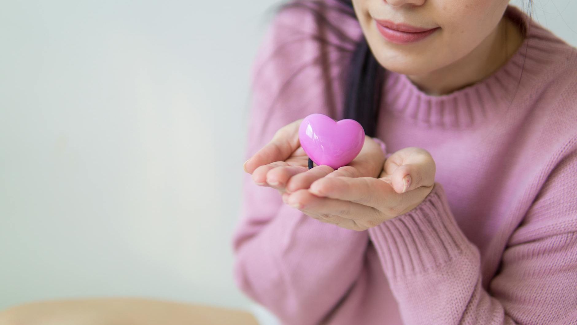 Person holding a heart in their hands.