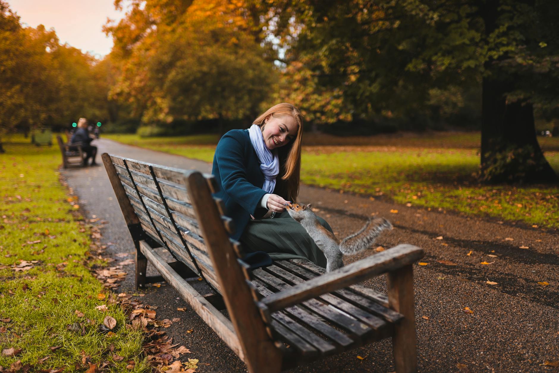 A person sitting in nature, surrounded by trees, with a serene expression on their face, representing the importance of spending time outdoors for mental health.