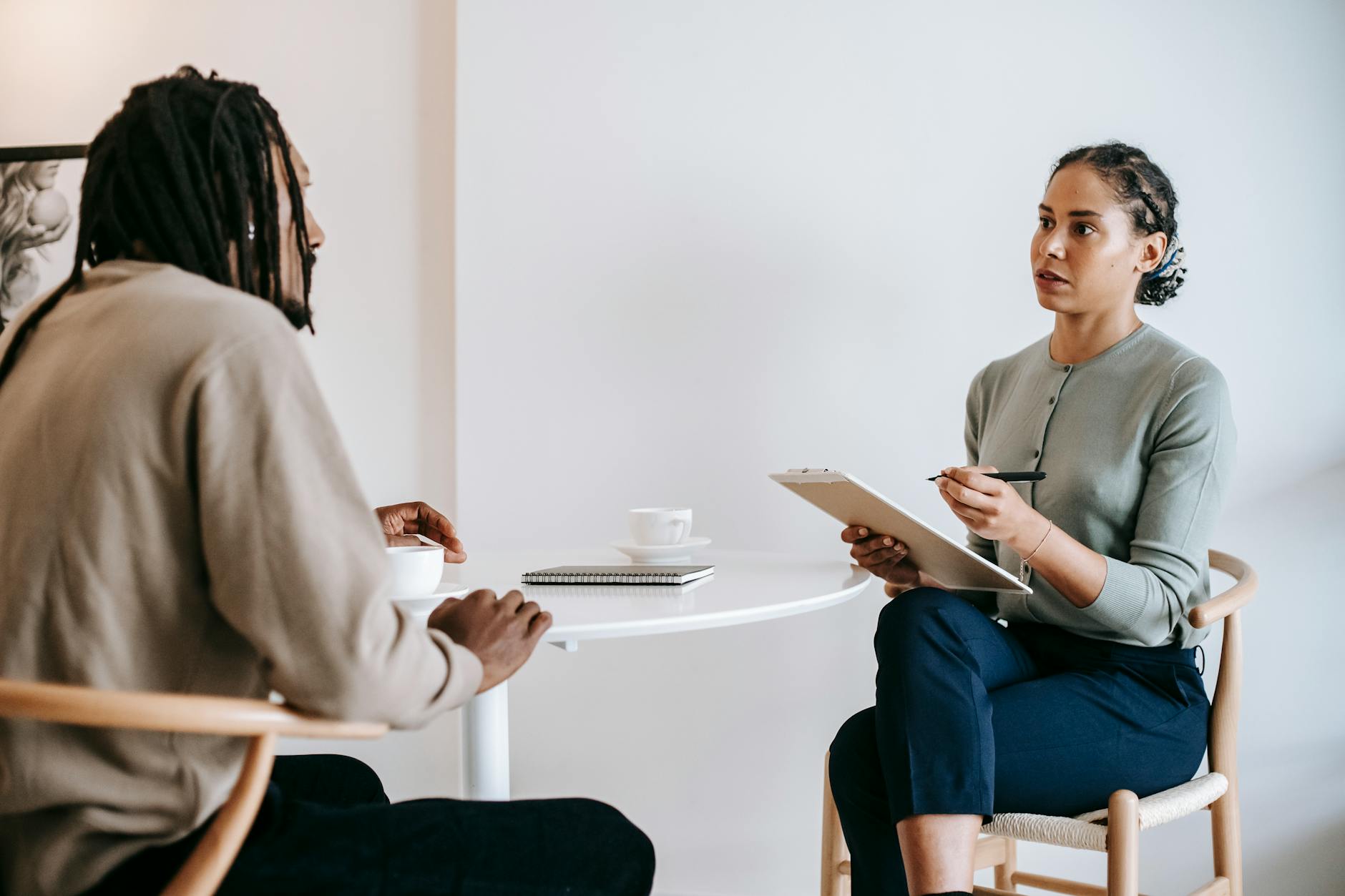 A supportive therapist listening attentively to a client during a therapy session.